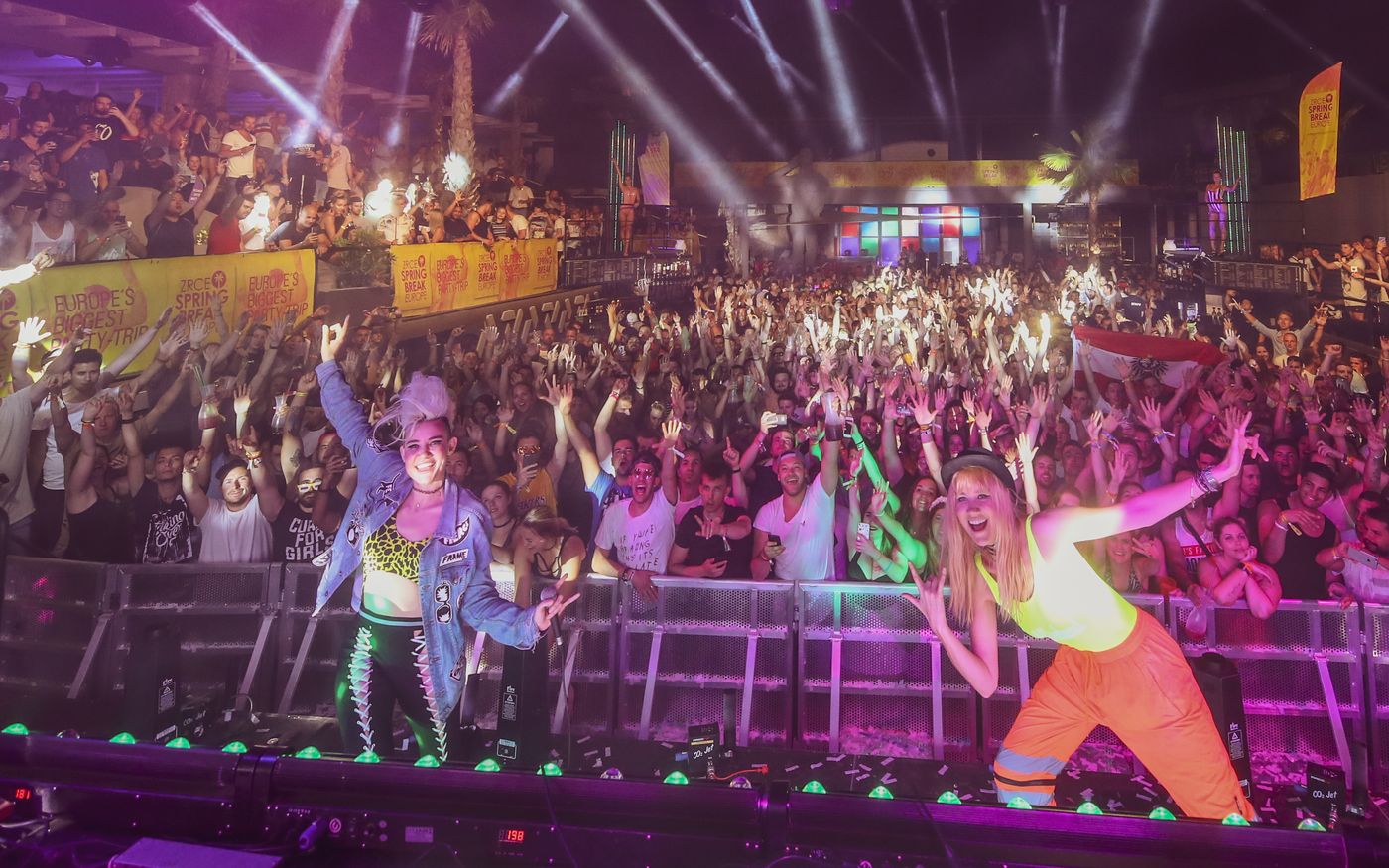 NERVO on stage in front of a huge Zrce Spring Break crowd with hands in the air under the lights