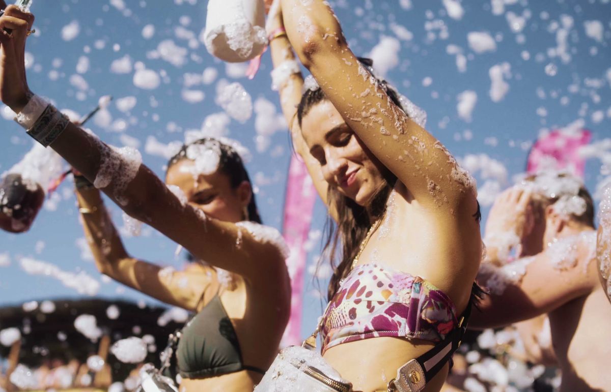 Friends dancing in the foam under a blue sky at Zrce Spring Break